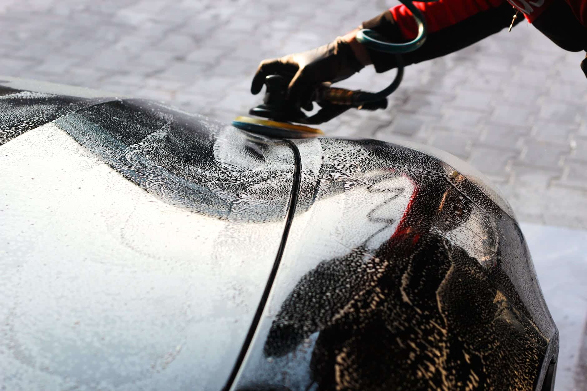 person waxing a car