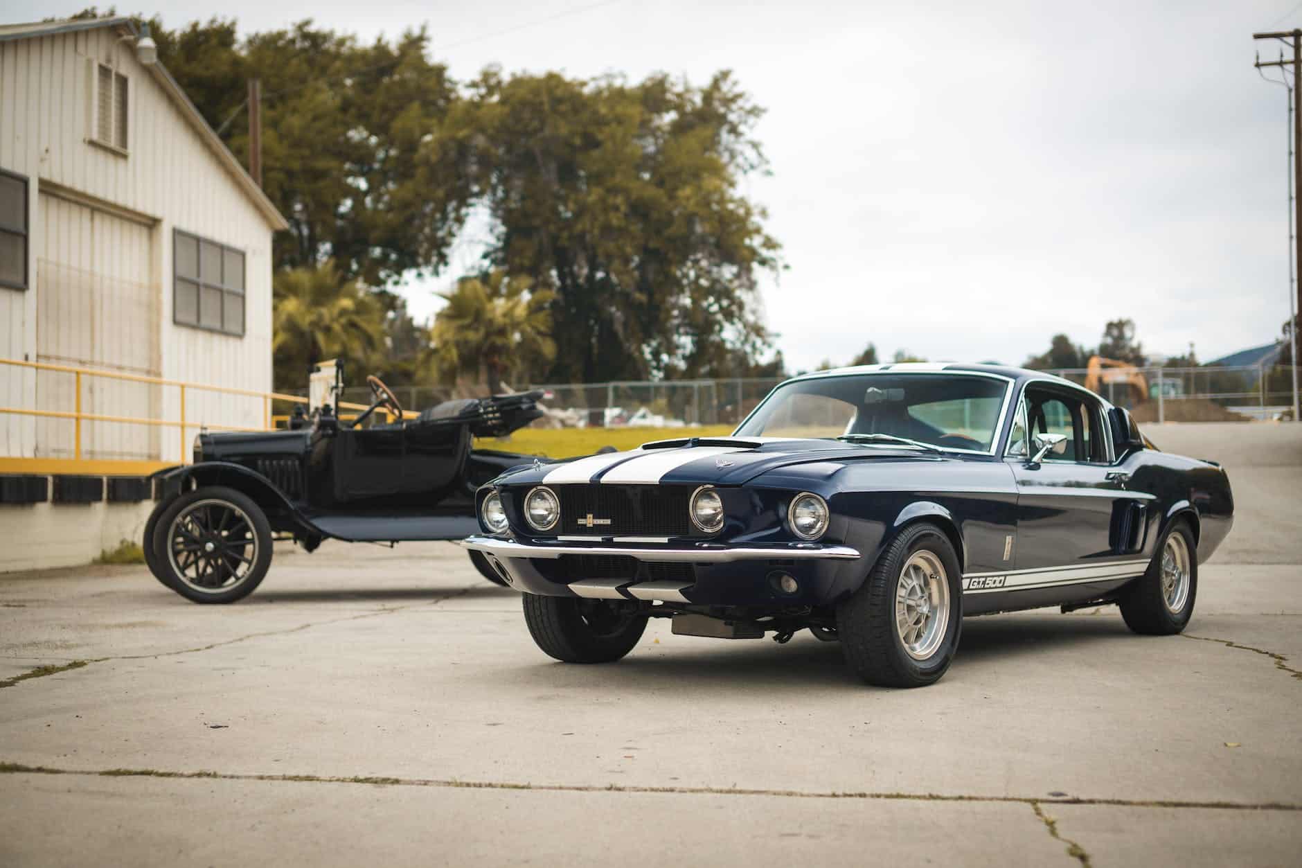 two black vintage cars parked near a building