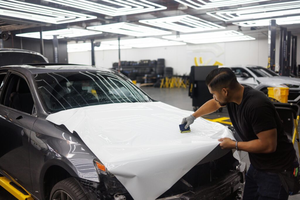 A car wrap installer installing a white car wrap color on a car.